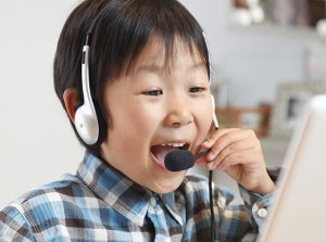 パソコンの前で笑う男の子